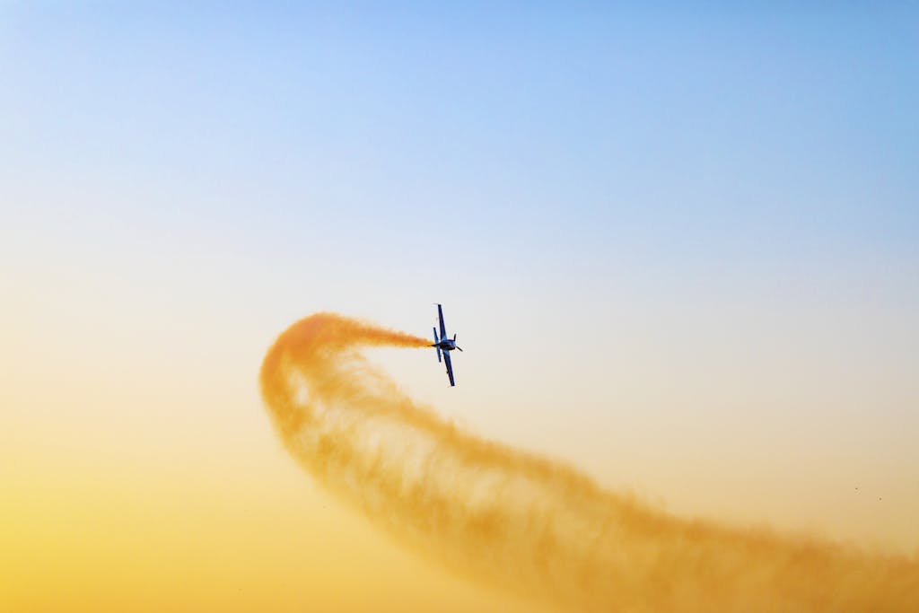 Airplane performing an aerial stunt against a vibrant sky in Dubai, UAE.