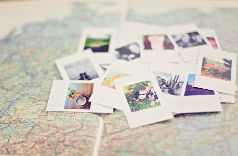 The World of pomerusky A collection of Polaroid memories spread across a map, symbolizing travel adventures.