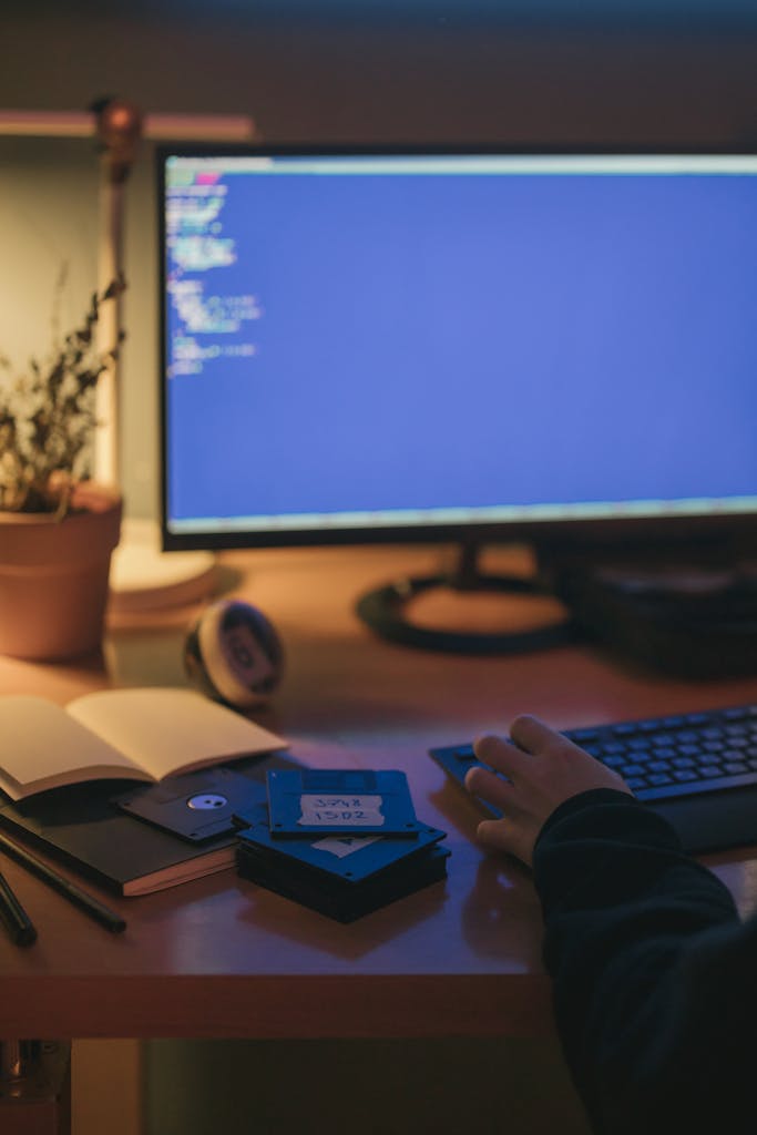 A home office setup with a computer screen displaying code, captured at night.