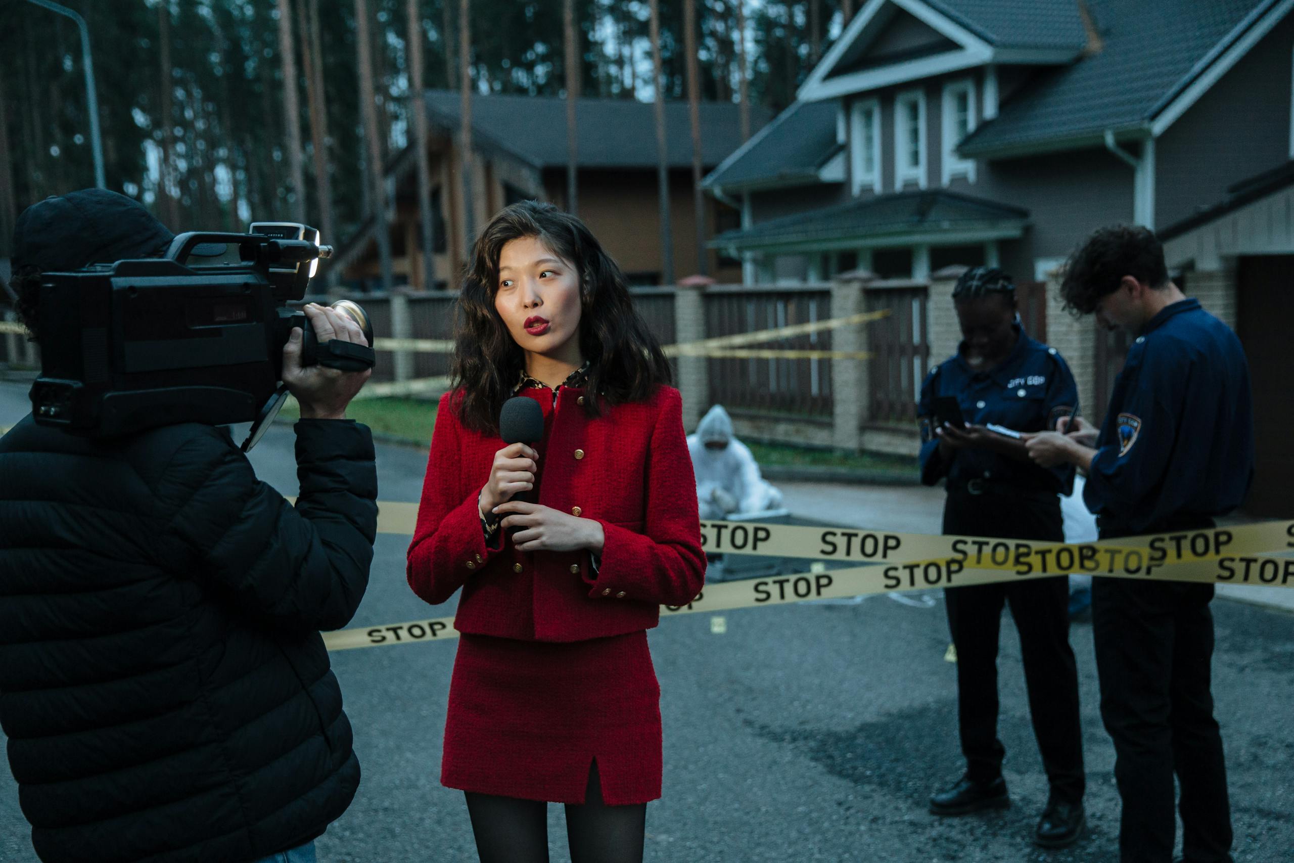 USA News TV A journalist reporting from a crime scene with police officers and cameraman.