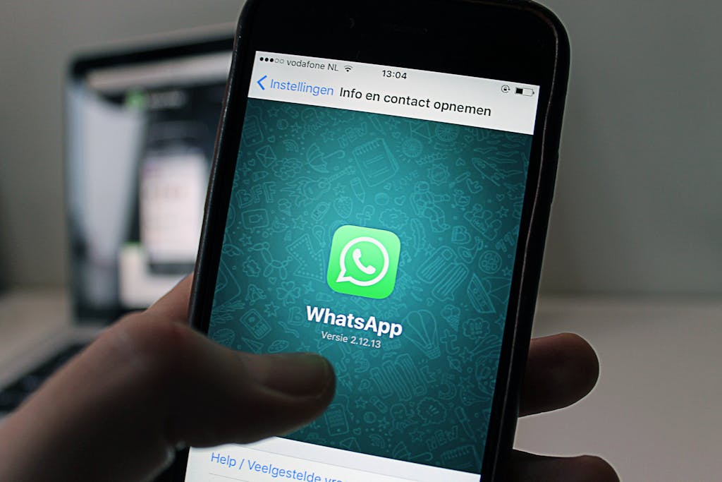 CHAS6D displaying the WhatsApp application screen held by a person.