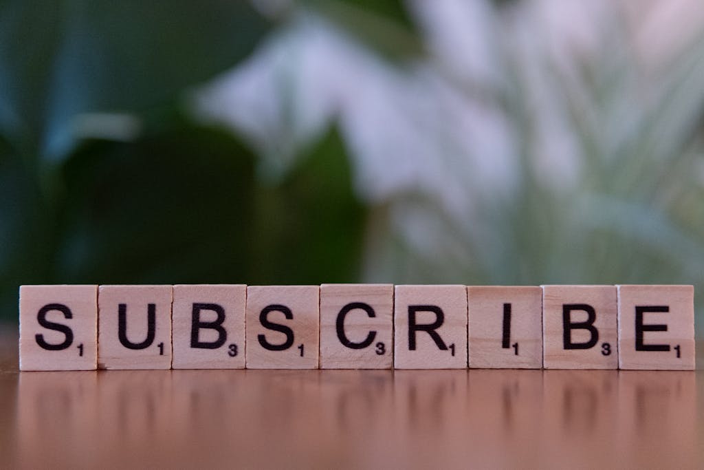 Game News eTrueSports Close-up of the word 'SUBSCRIBE' spelled with wooden letter tiles on a table.