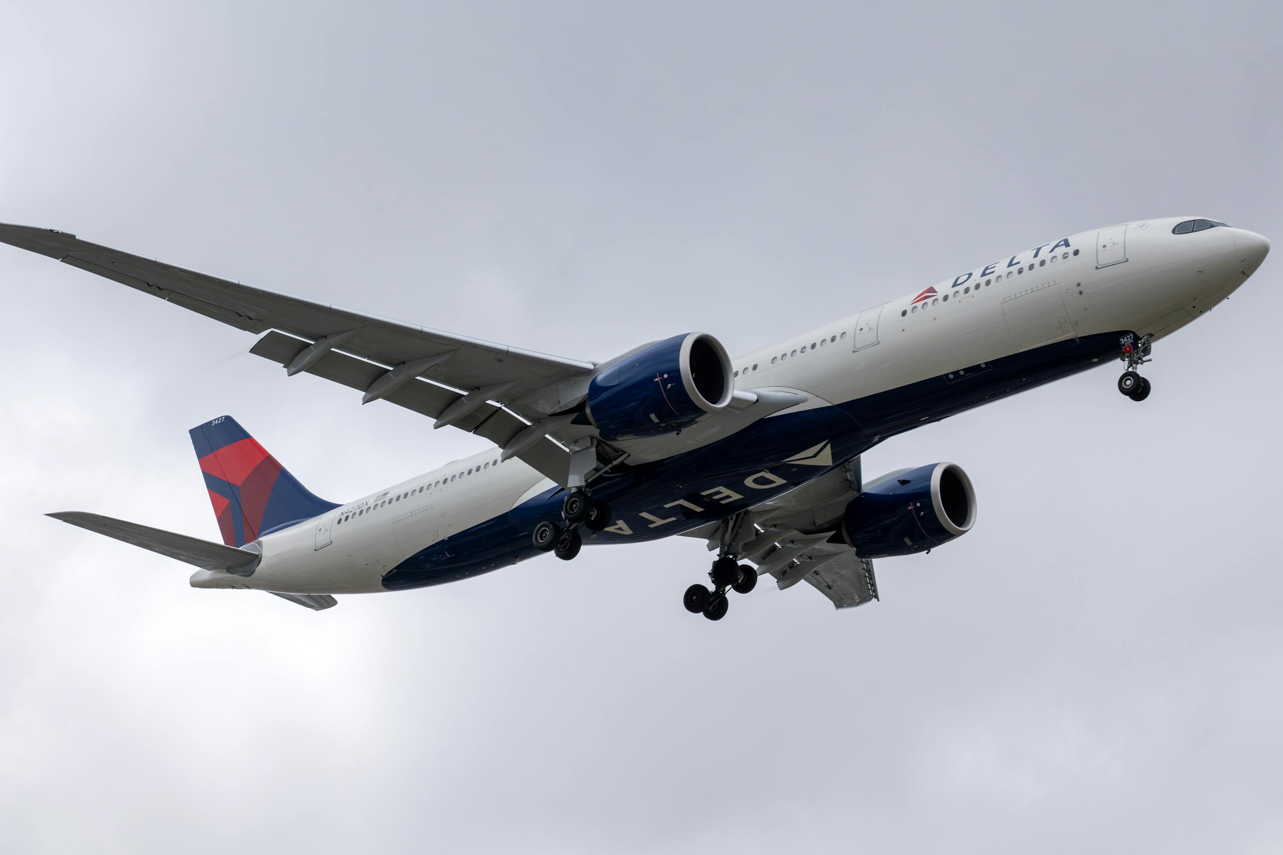 Delta Flight DL275 Diverted to LAX Delta Airlines aircraft in descent over Los Angeles, cloudy sky.