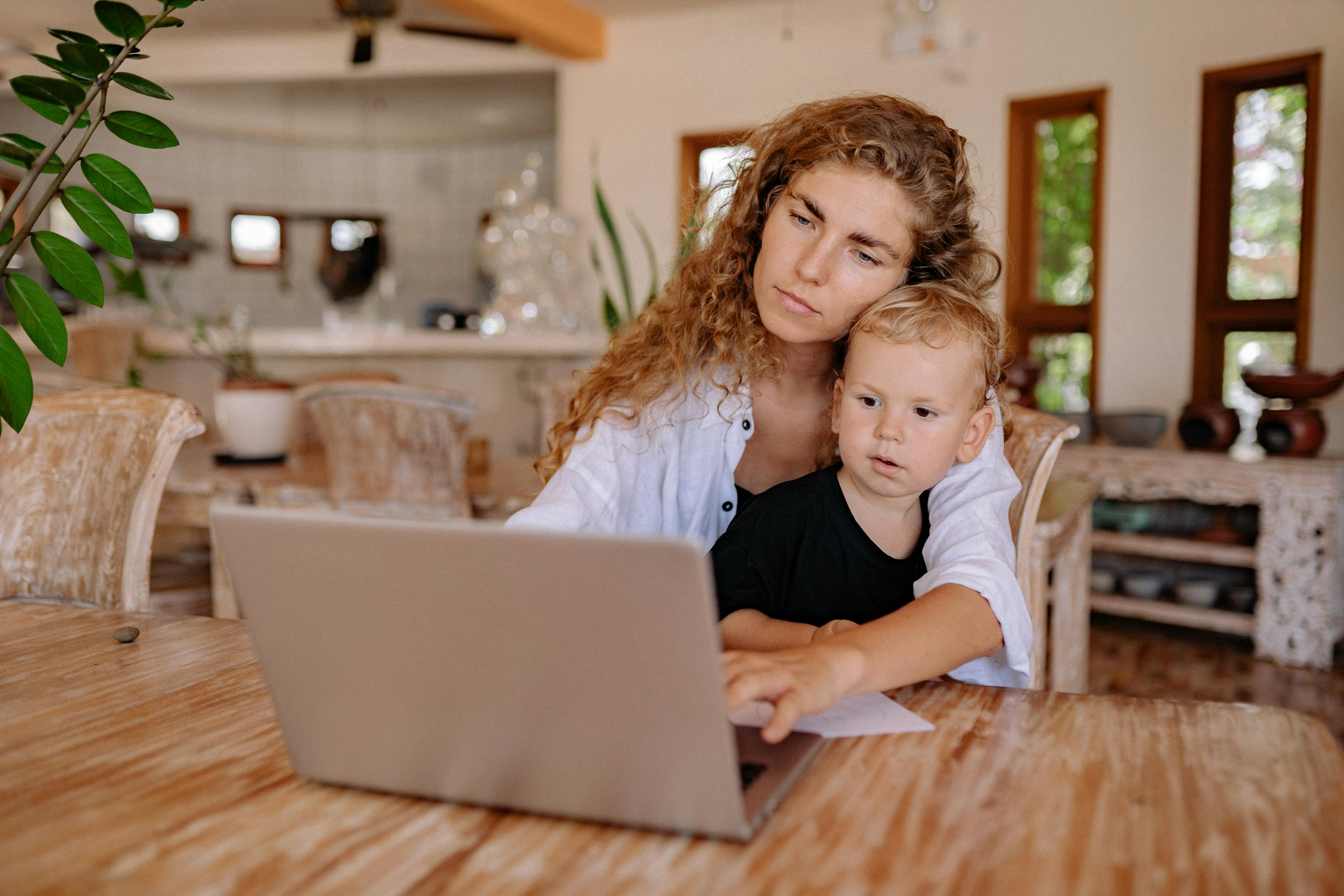 Newsatrack: A Complete Guide to Smarter News, Trends, and Digital Awareness Mother and child using a laptop at home, working and bonding in a cozy environment.