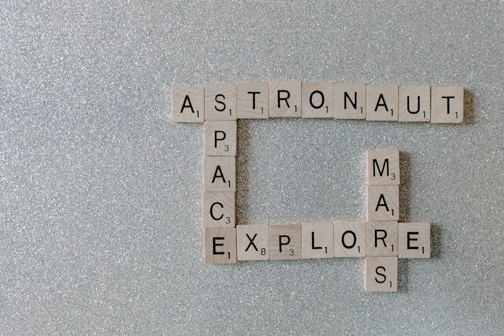 The Globe and Mail Crossword Puzzle Wooden Scrabble tiles forming words related to space exploration on a glittery surface.