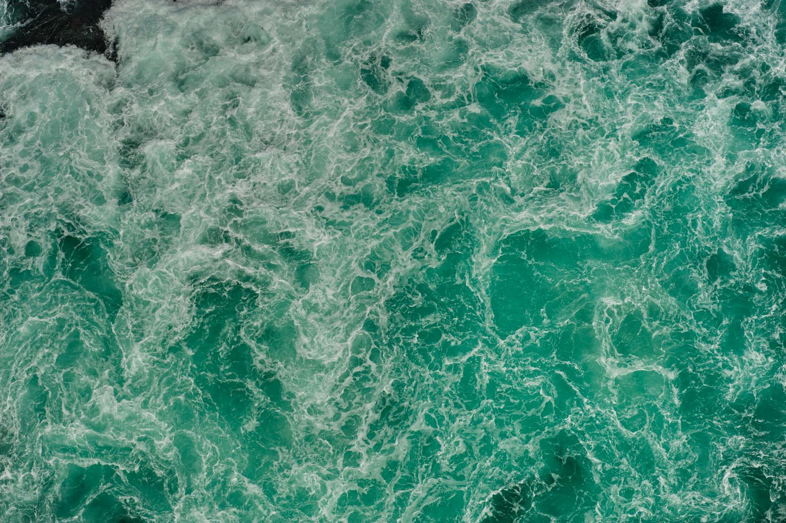 Game Naruto Senki Aerial shot of swirling turquoise waters in Naruto, Tokushima, Japan, capturing nature's power.