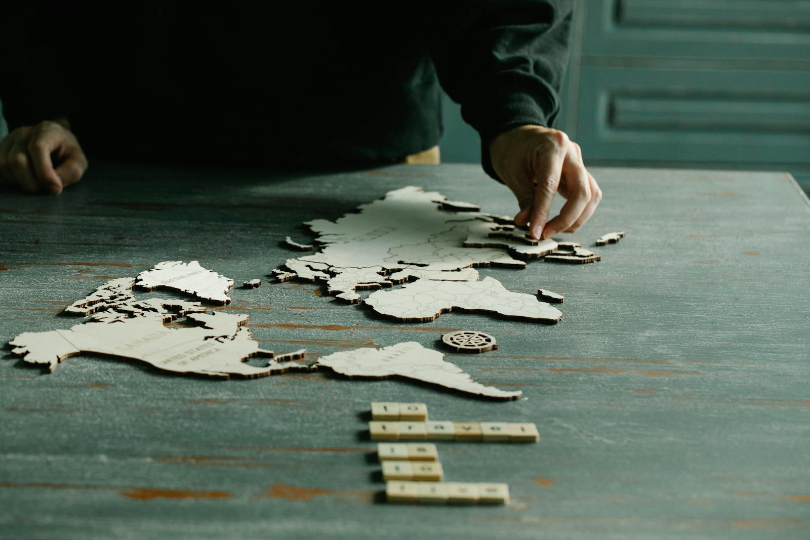 Naruto Senki Game – Complete In-Depth Article A person arranging a wooden puzzle of a world map on a rustic wooden table.