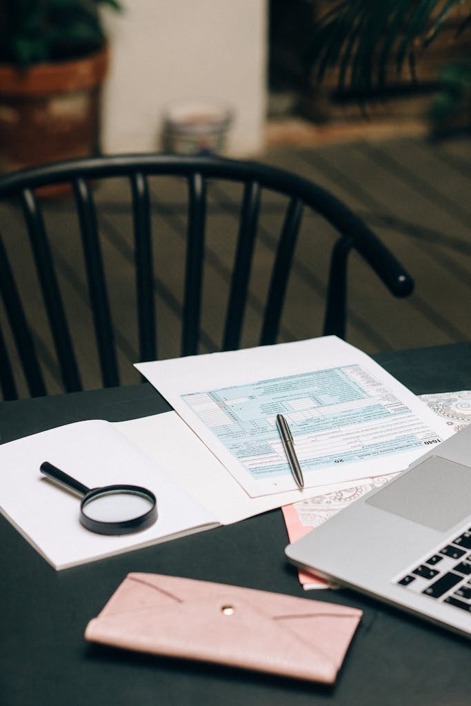 A modern office desk with a laptop, documents, and stationery, providing a professional setup.