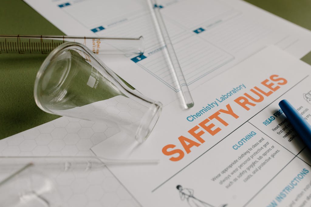 RWU UAR: An image of laboratory safety rules and glassware in a chemistry lab.