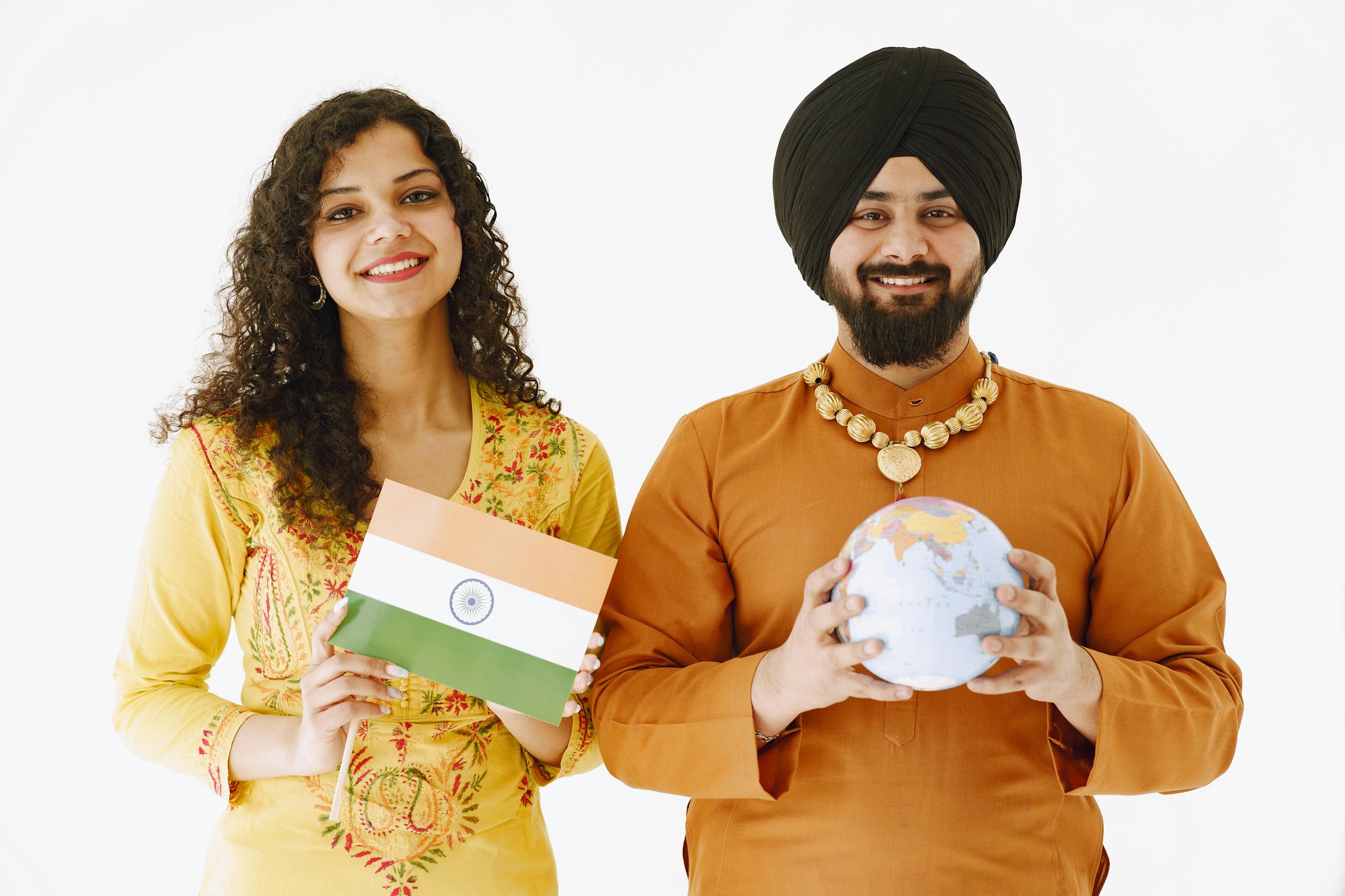 Asian Pinay: Happy Indian couple in traditional attire holding a flag and globe against a white background.