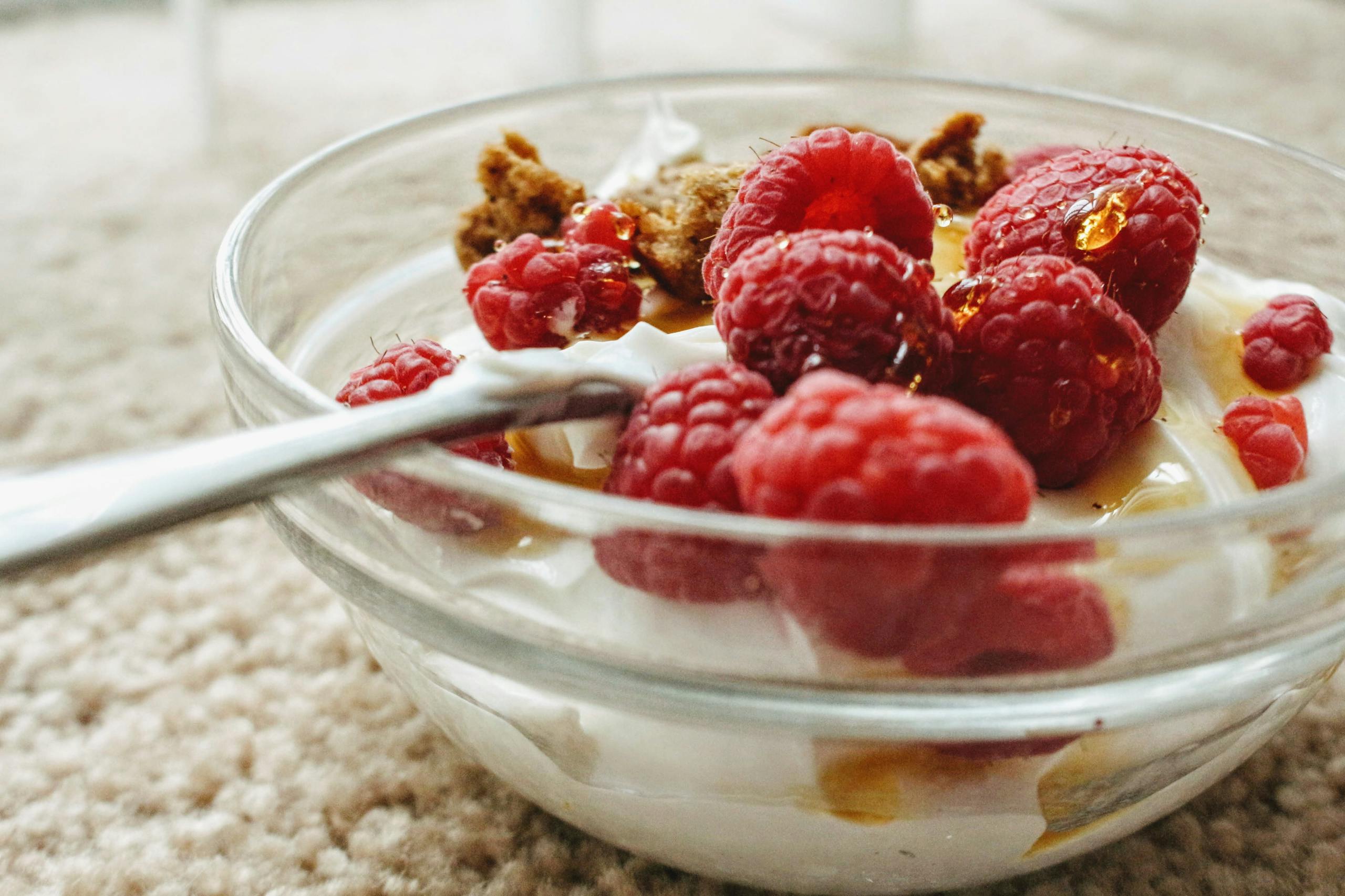 Top 5 Fat-Burning Foods to Boost Your Diet Indulge in creamy yogurt topped with fresh raspberries and sweet honey in a glass bowl.