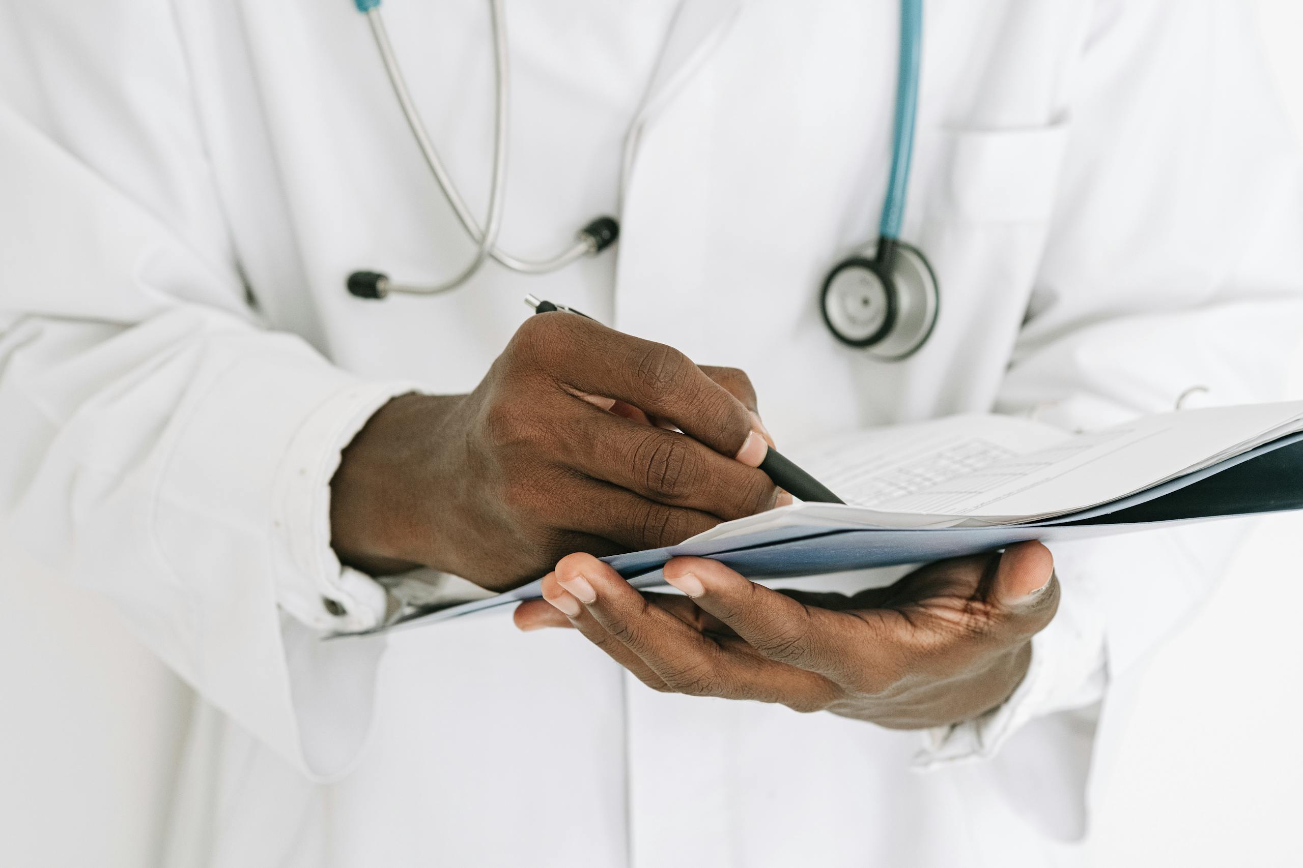 Inomyalgia: Causes, Symptoms, Diagnosis, and Treatment Guide Professional doctor writing on a clipboard with a stethoscope in a medical office.