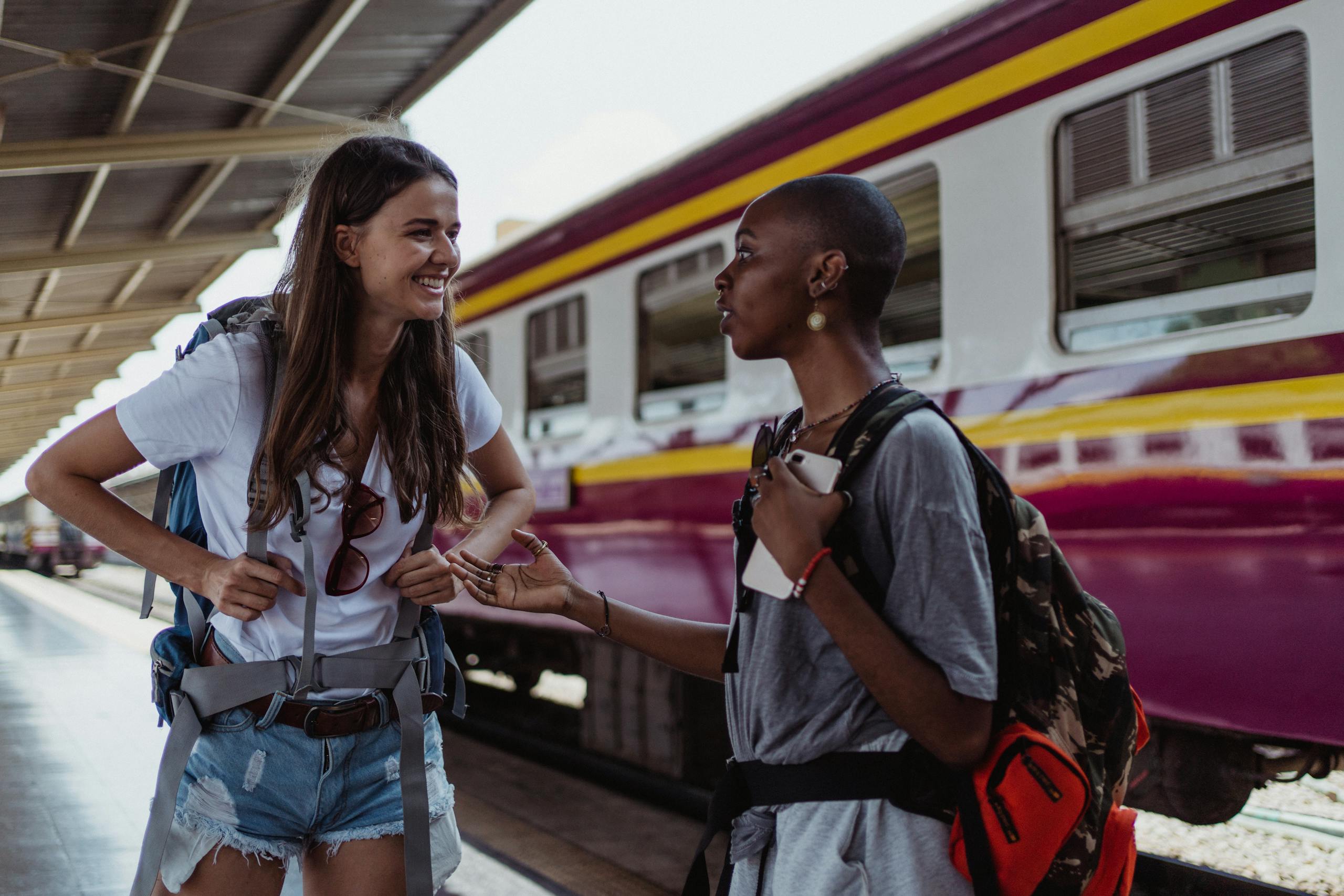 MSN News: A Complete Guide to Microsoft’s Global News Platform Two backpackers engage in friendly conversation at a railway station, with a train in the background.