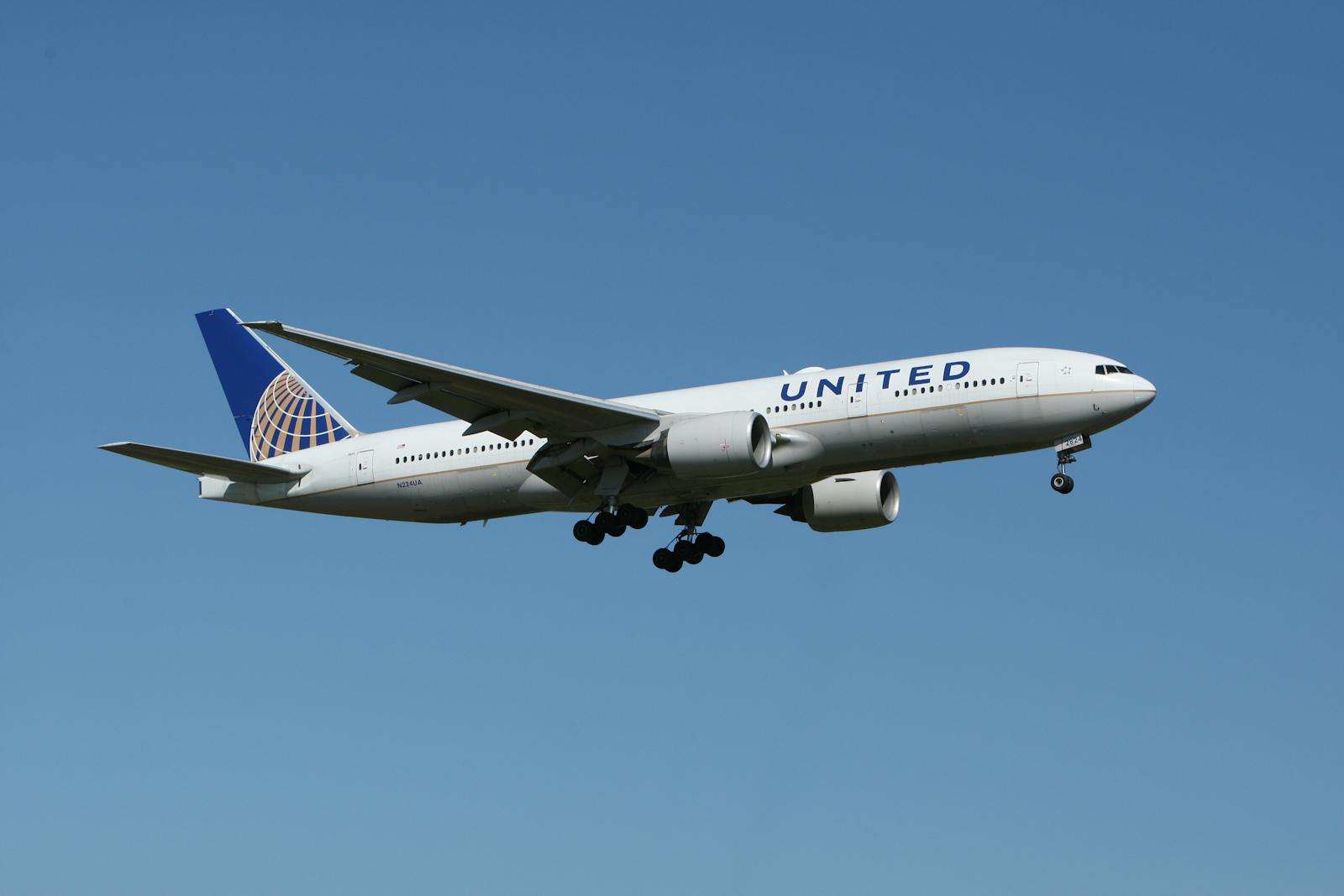 United Flight UA109 Diversion A United airliner flying against a clear blue sky, showcasing air travel.