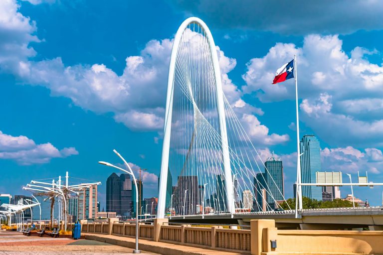 Texas The iconic Margaret Hunt Hill Bridge in Dallas, Texas under a bright blue sky with clouds.