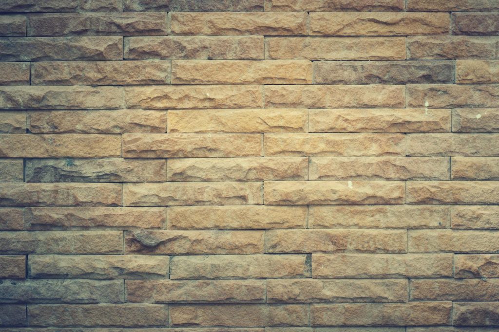 MMSBRE Rustic brown brick wall with textured pattern, perfect for backgrounds and design elements.