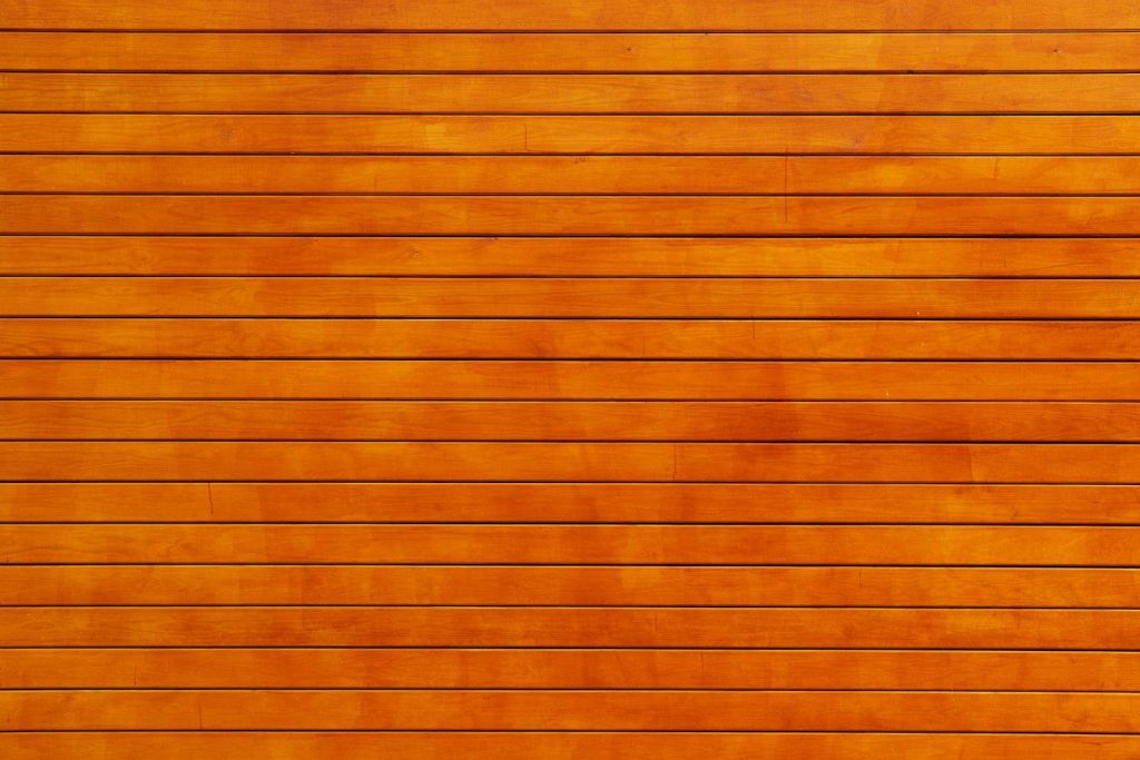 edivawer Close-up of a vibrant orange wooden wall texture, ideal for backgrounds.