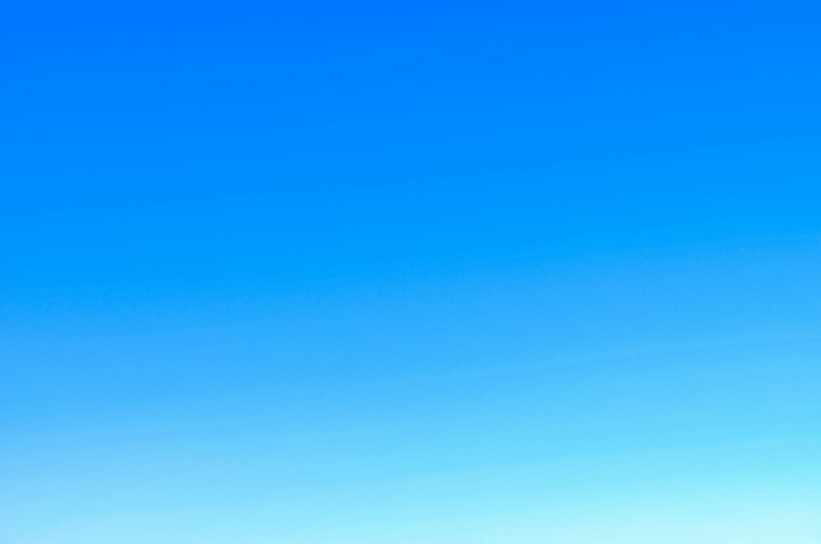 A serene view of a vibrant clear blue sky with a subtle gradient, perfect for backgrounds.