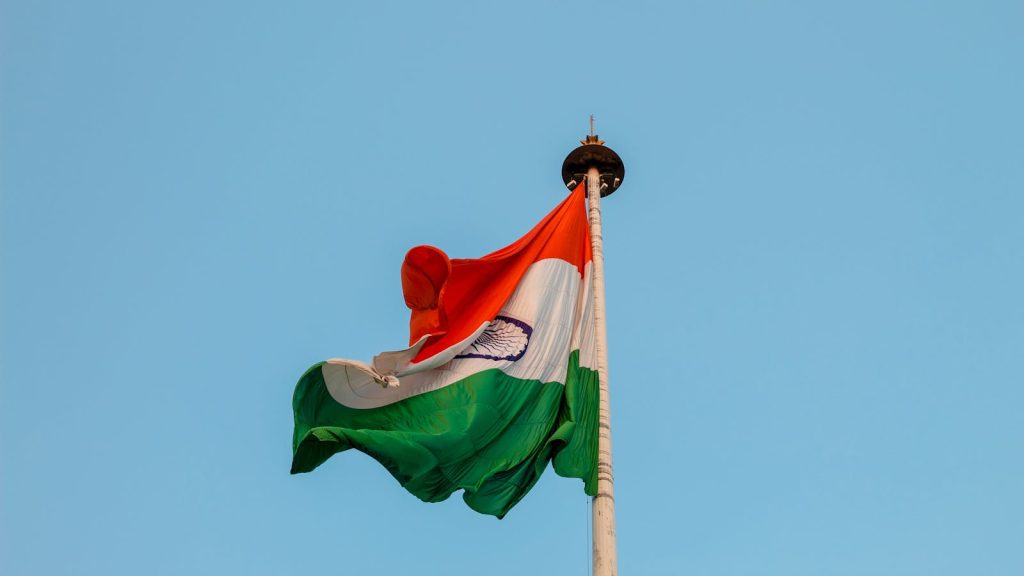 Indian national flag waving proudly against a clear blue sky in Jaipur, symbolizing patriotism and unity.