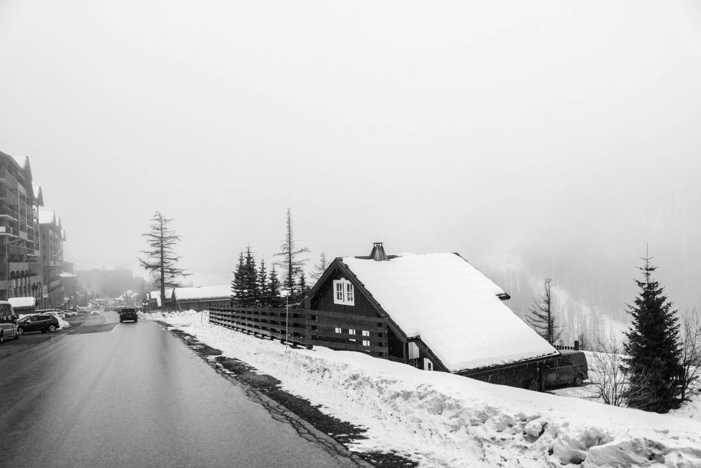 A tranquil snowy chalet scene captured in monochrome, highlighting winter's serene beauty.