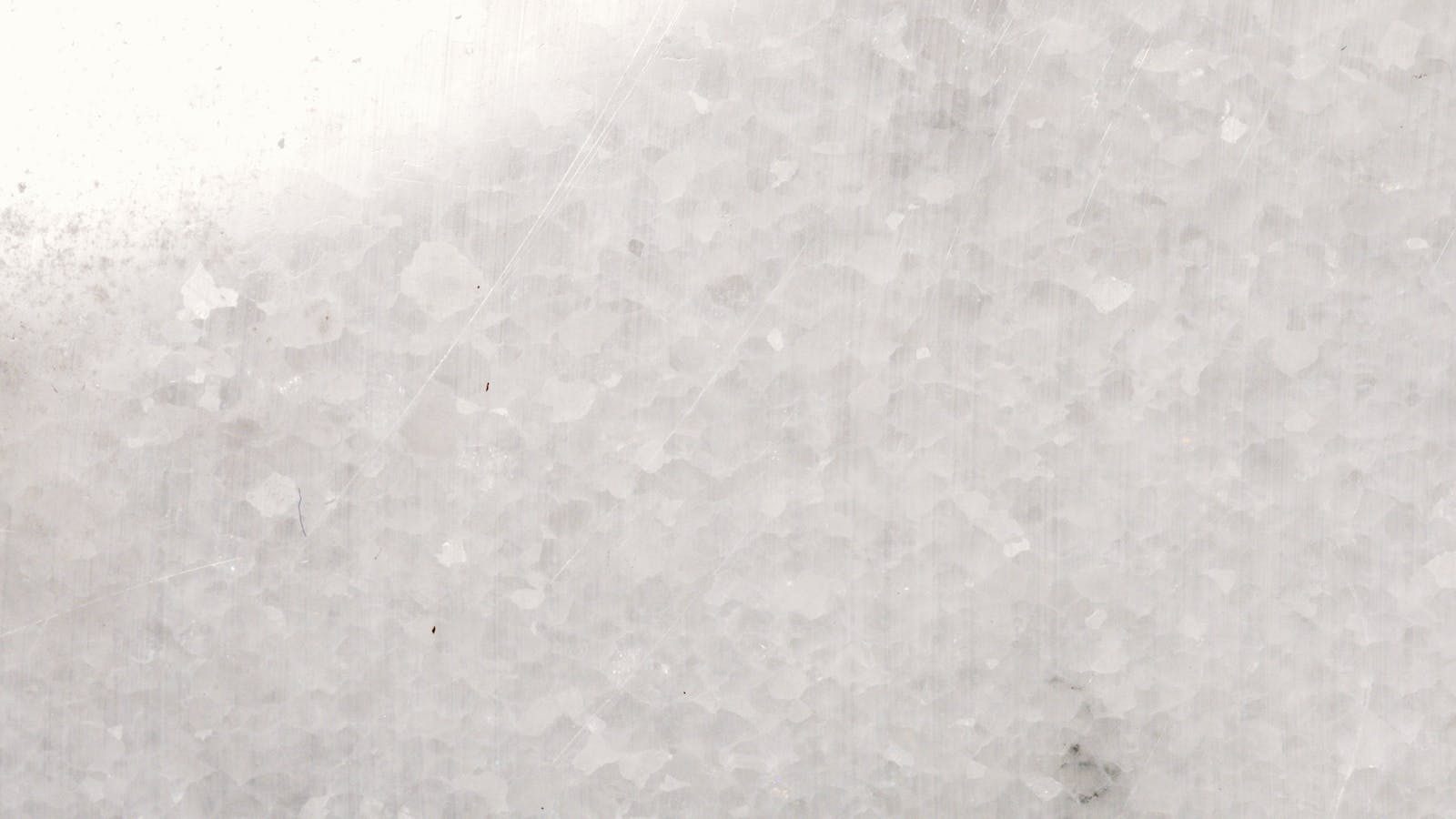 Permanentad A detailed close-up of white marble surface showcasing texture and patterns.