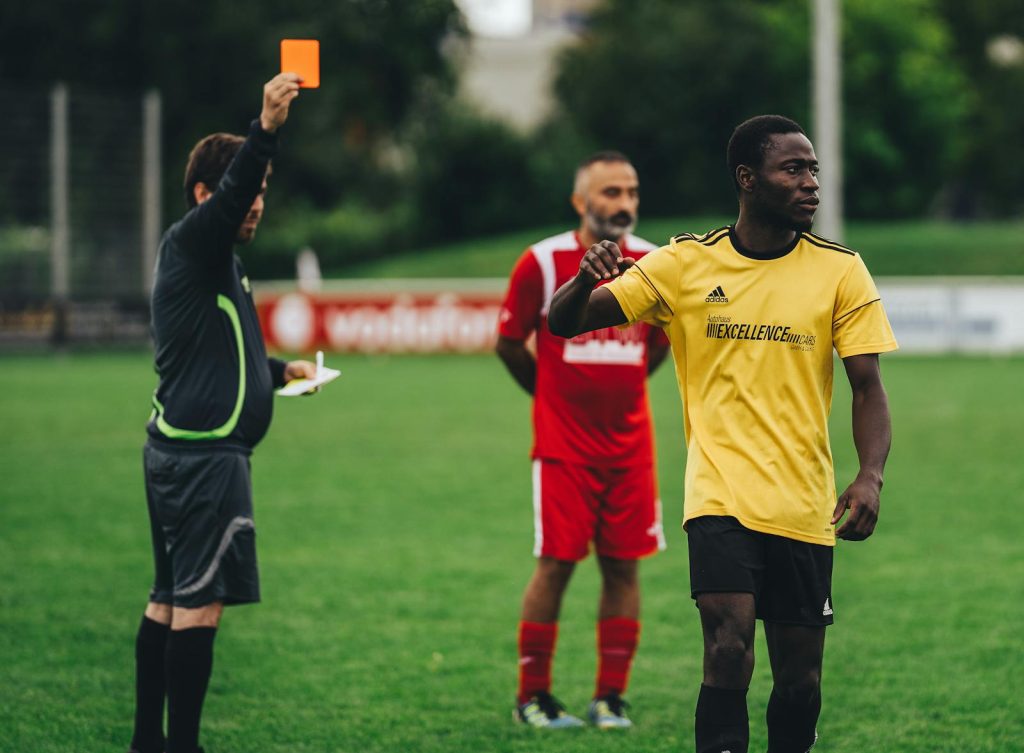 Bengals vs Cleveland Browns Match Player Stats  Referee issuing a red card to a soccer player in an outdoor match setting.