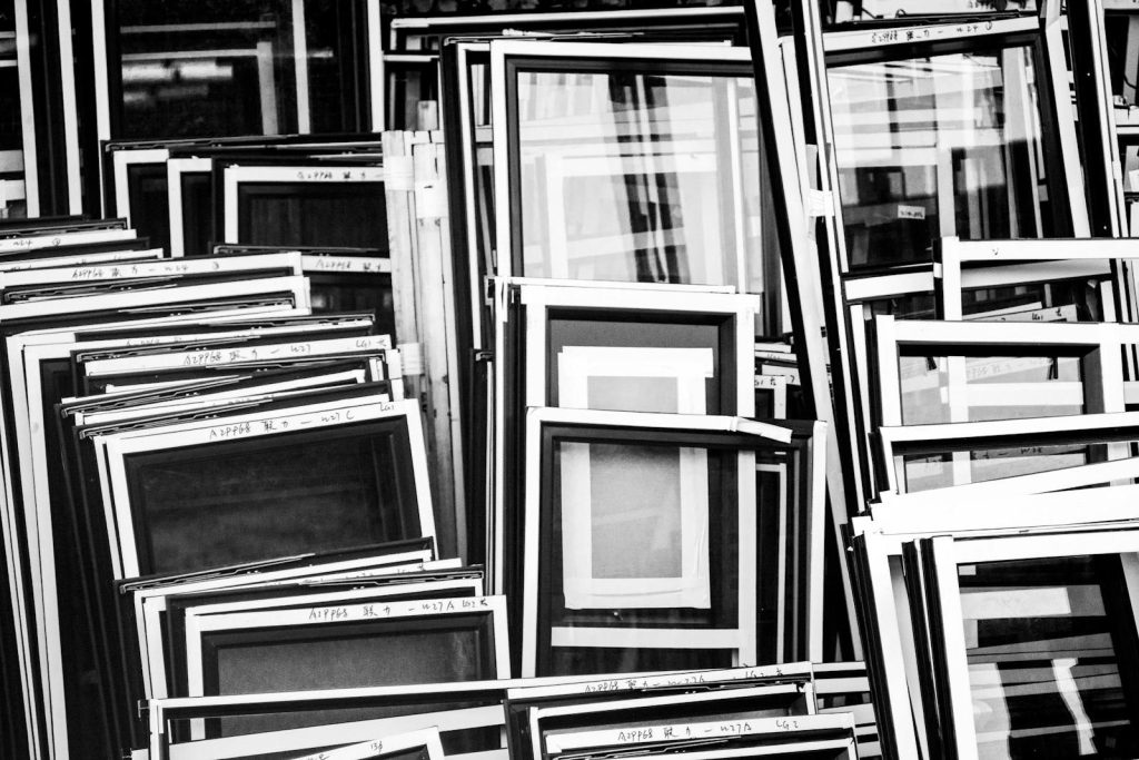 Dolfier A collection of window frames stacked in Kowloon, Hong Kong, in a black and white composition.