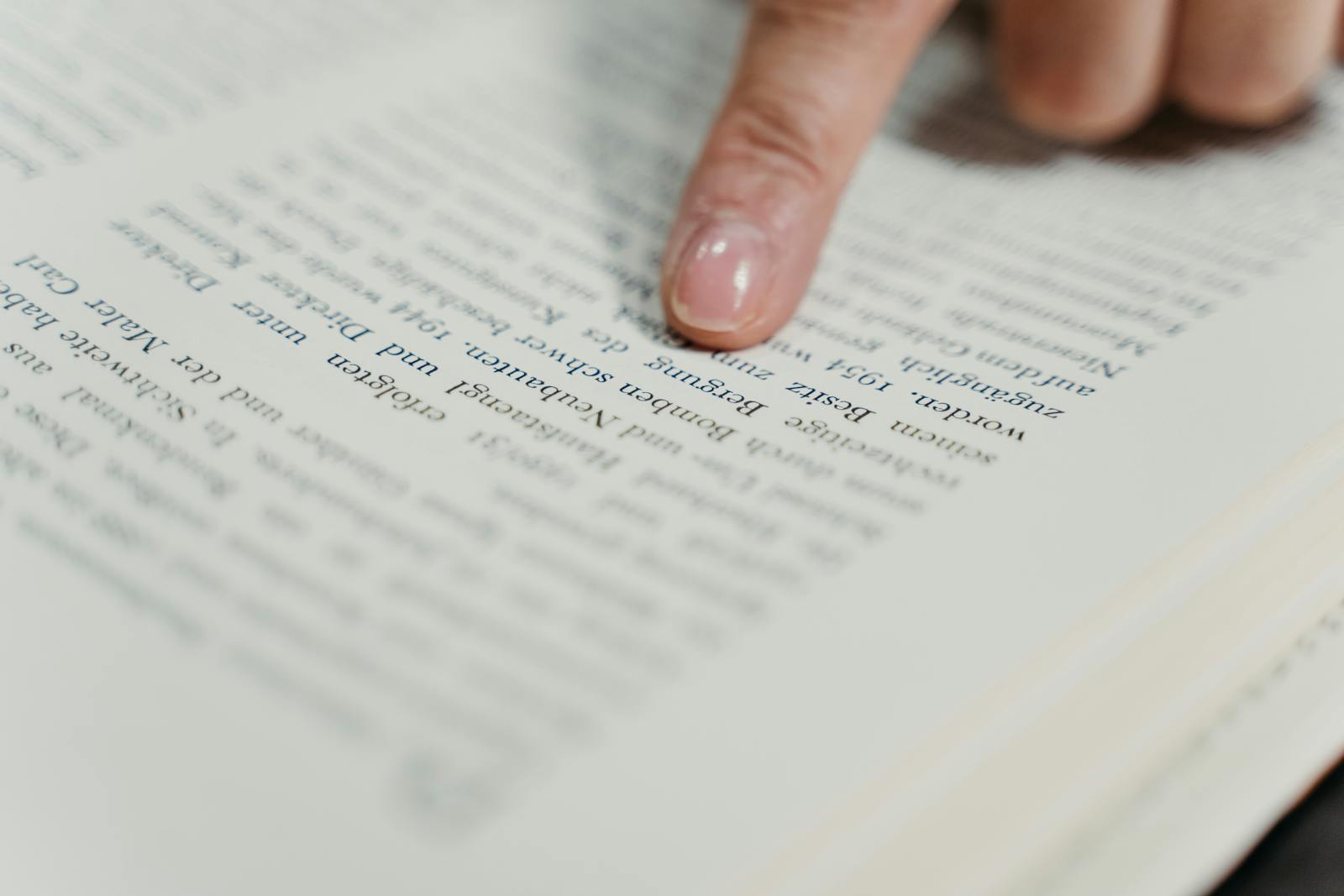 The Comprehensive Guide to buscrs A detailed view of a finger pointing at text in a book, emphasizing reading and study.