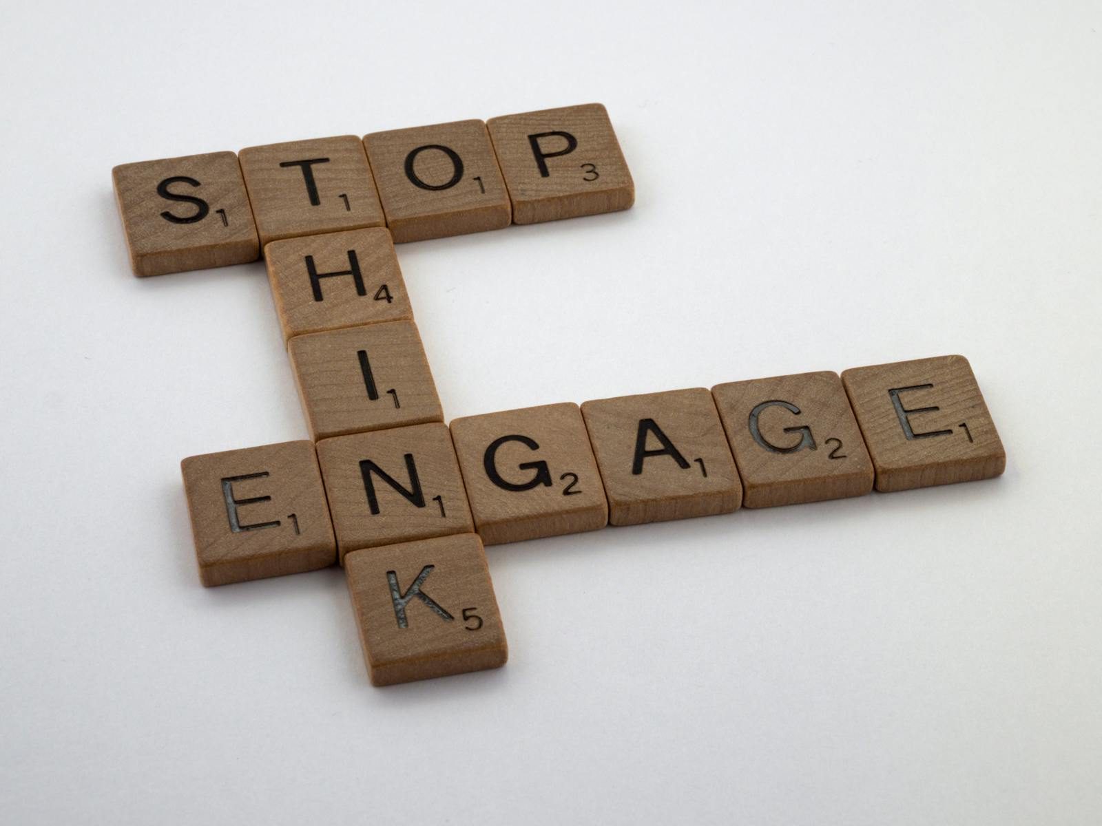 Phil or Lil of Rugrats Crossword Wooden Scrabble tiles spelling 'Stop Think Engage' for strategic concepts.